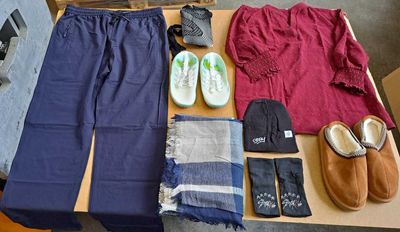 a table with a variety of clothing and shoes on it