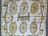 a close up of a white and gold scarf on a table