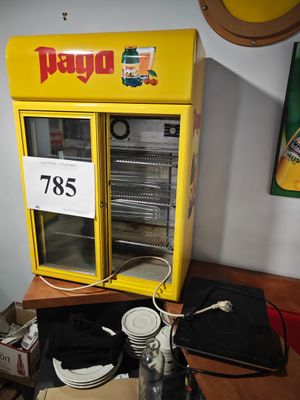 un distributeur automatique jaune posé sur une table en bois, près d'un mur