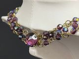 purple and gold beaded necklace on a mannequin neck