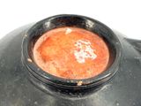 a black bowl with a red substance inside of it