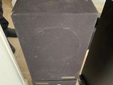 a black speaker sitting on top of a wooden table
