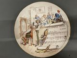 a plate with a picture of a musical scene on it