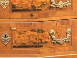 a wooden chest of drawers with a painting on it