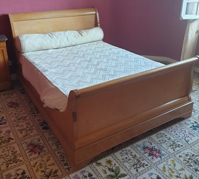 un lit avec un cadre en bois dans une chambre aux murs roses