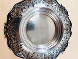 a silver plate on the wall with a mirror in it
