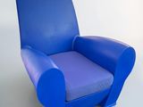 a blue chair that is sitting on a white floor