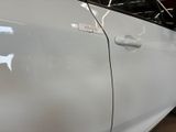 the door of a white car with a sticker on it ' s side