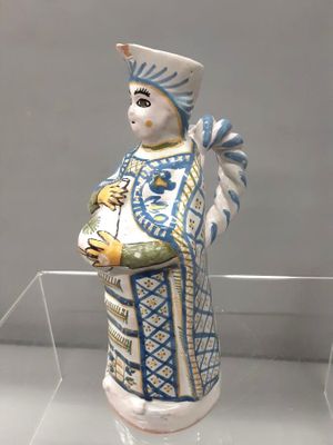 une figurine représentant une femme vêtue d'une robe bleue et blanche