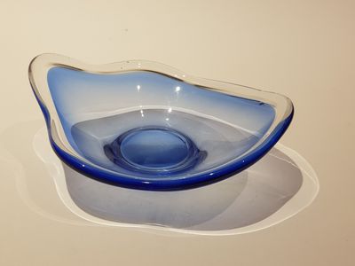 un bol bleu posé sur une assiette blanche, sur une table