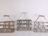 three metal baskets with handles hanging on a white wall