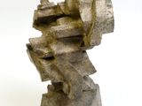 une sculpture en pierre posée sur une surface blanche