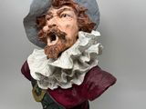 statue of a man with a beard wearing a hat and a red scarf