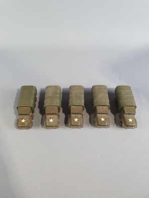 five toy army vehicles are lined up in a row on a white surface