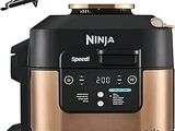 une friteuse à air chaud Ninja noire et dorée à côté d'un mixeur noir et doré