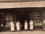 trois hommes debout devant un magasin, avec des bouteilles d'alcool