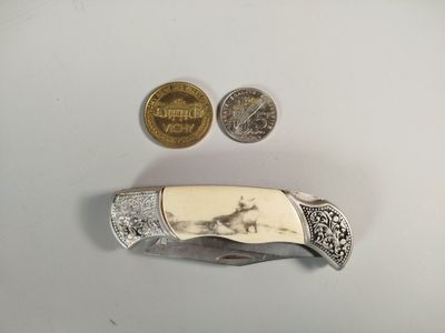 un petit couteau posé à côté d'une pièce de monnaie