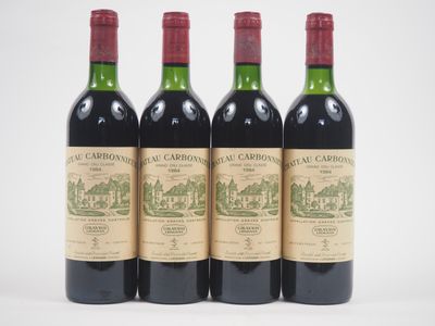 trois bouteilles de vin rouge sont alignées sur une surface blanche
