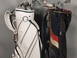 deux clubs de golf sont alignés l'un à côté de l'autre sur une surface grise