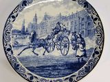 a blue and white plate with a picture of a horse drawn carriage