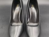 a pair of silver shoes on a gray surface