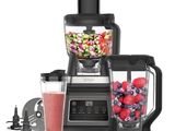 un mixeur contenant des fruits et des légumes, à côté d'un autre mixeur