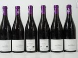 six bottles of wine are lined up in a row on a table