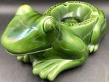 a green frog figurine sitting on a table