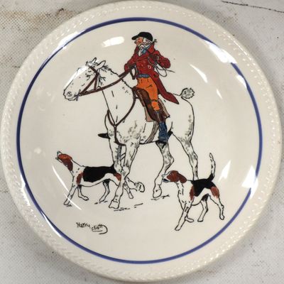 une assiette sur laquelle est représenté un homme à cheval, accompagné de chiens