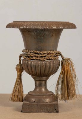 un vase en argent surmonté d'un pompon