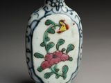 a small vase with a bird and flowers on it