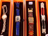 Plusieurs montres se trouvent dans une boîte, chacune étant attachée à une chaîne.