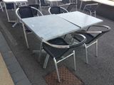 many chairs and tables on the sidewalk outside of a restaurant