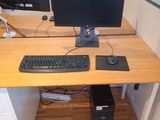 a computer desk with a keyboard and a monitor on it