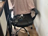 a black chair with a pink blanket on it in the corner of a room