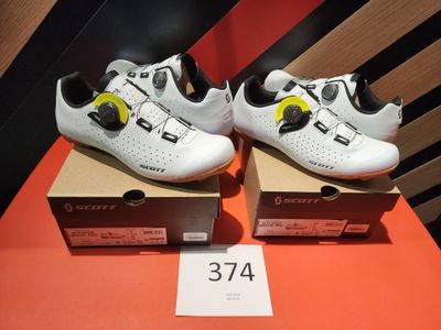 two pairs of white shoes are on display on a table