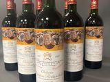 six bouteilles de vin sont alignées sur une table