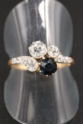 un gros plan d'une bague sertie d'un saphir bleu et de diamants blancs
