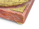 a red marble box with a gold decoration on it