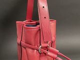 a pink purse with a metal ring on the handle