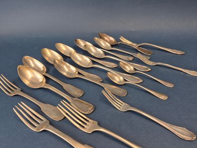 six cuillères et six fourchettes sont alignées sur une surface bleue