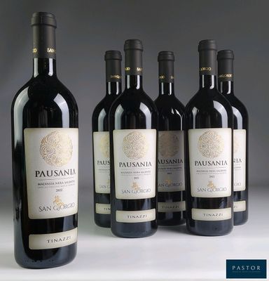 quatre bouteilles de vin rouge sont alignées sur une table