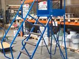 une plate-forme bleue sur laquelle se trouve une échelle, dans un entrepôt