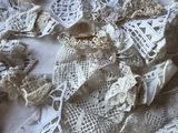 a pile of lace on a table with a pair of scissors on it