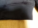 the back of a black jacket with a zipper on it