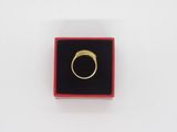 an image of a gold ring in a red box on a white surface