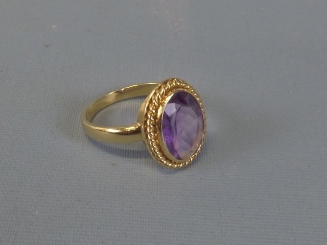 Bague en or jaune 750 millièmes ornée au centre d’une améthyste s...