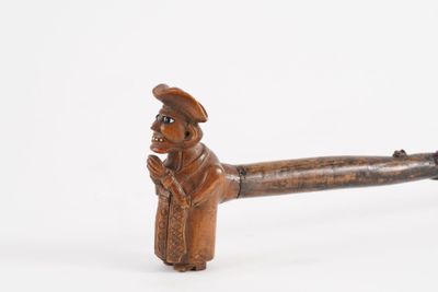 a small wooden pipe with a man in a hat on it