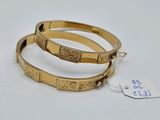 deux bracelets en or ornés de motifs gravés, accompagnés d'une étiquette de prix