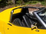 a yellow sports car with a black interior parked in a lot